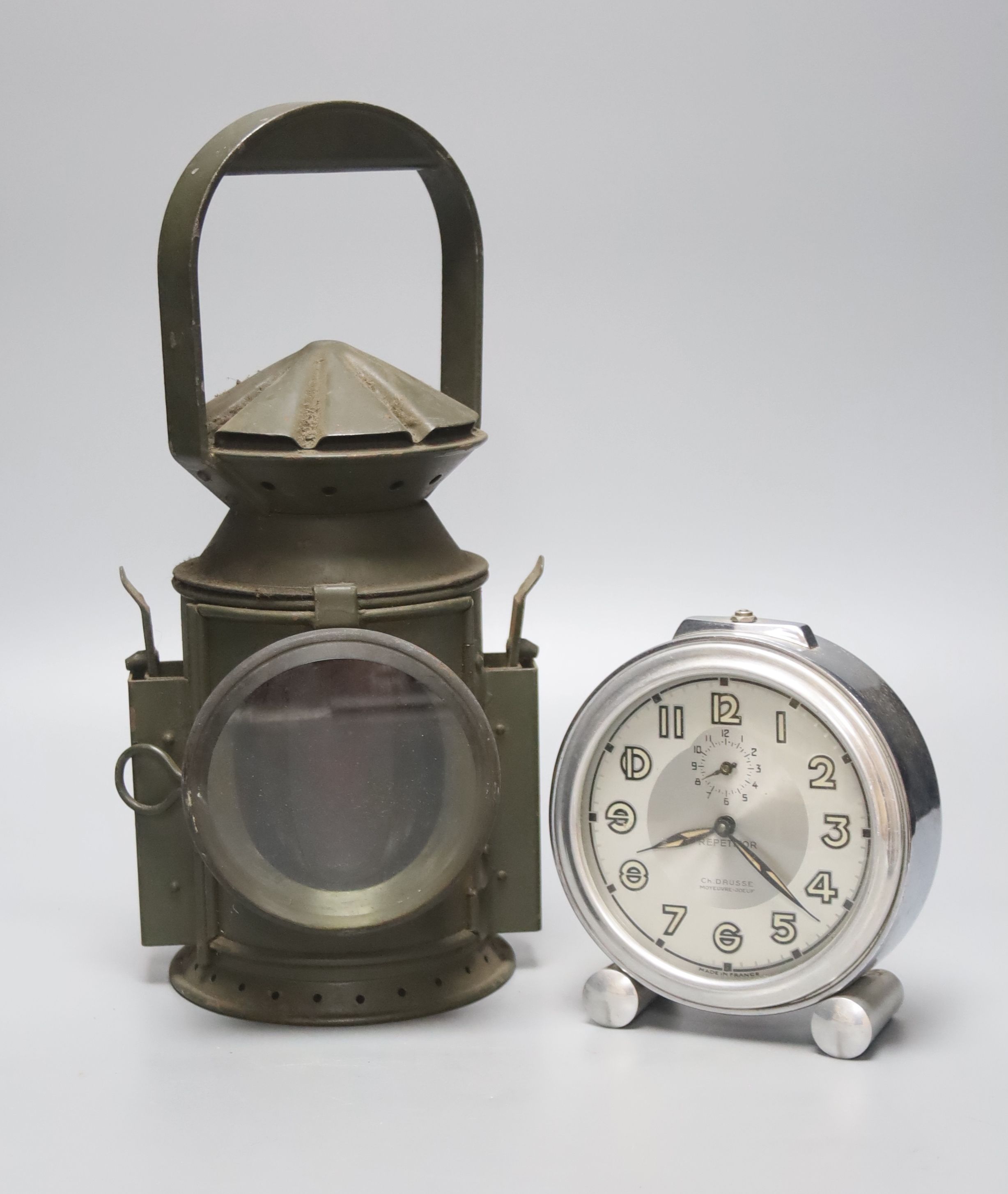 A green painted railway lantern, 30cm high, together with a French chrome cased alarm clock,